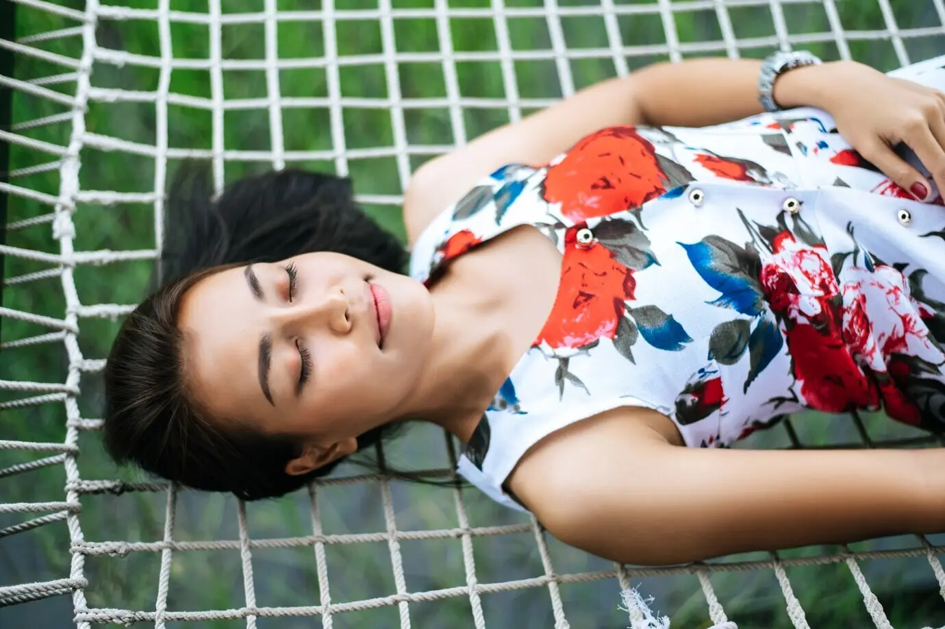 Auf einem Netzseil liegende Frau